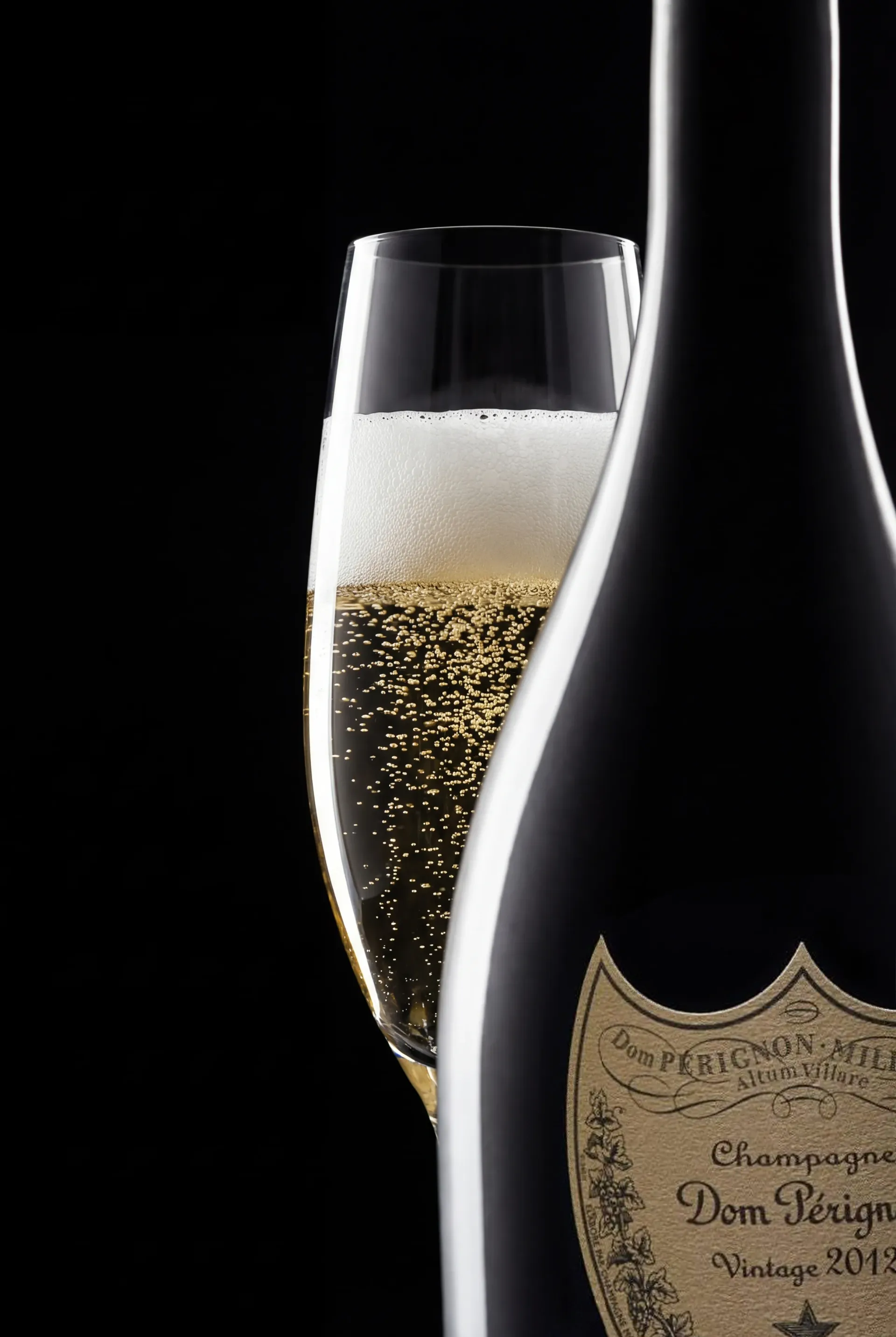 Dom Perignon bottle in near silhouette beside a flute of champagne, a thin rim light tracing the dark glass.